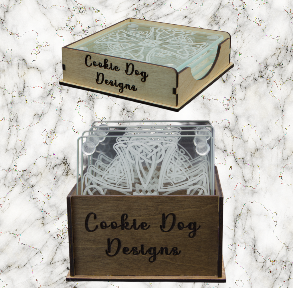 Wooden boxes with 'Cookie Dog Designs' branding containing coasters on a marble background