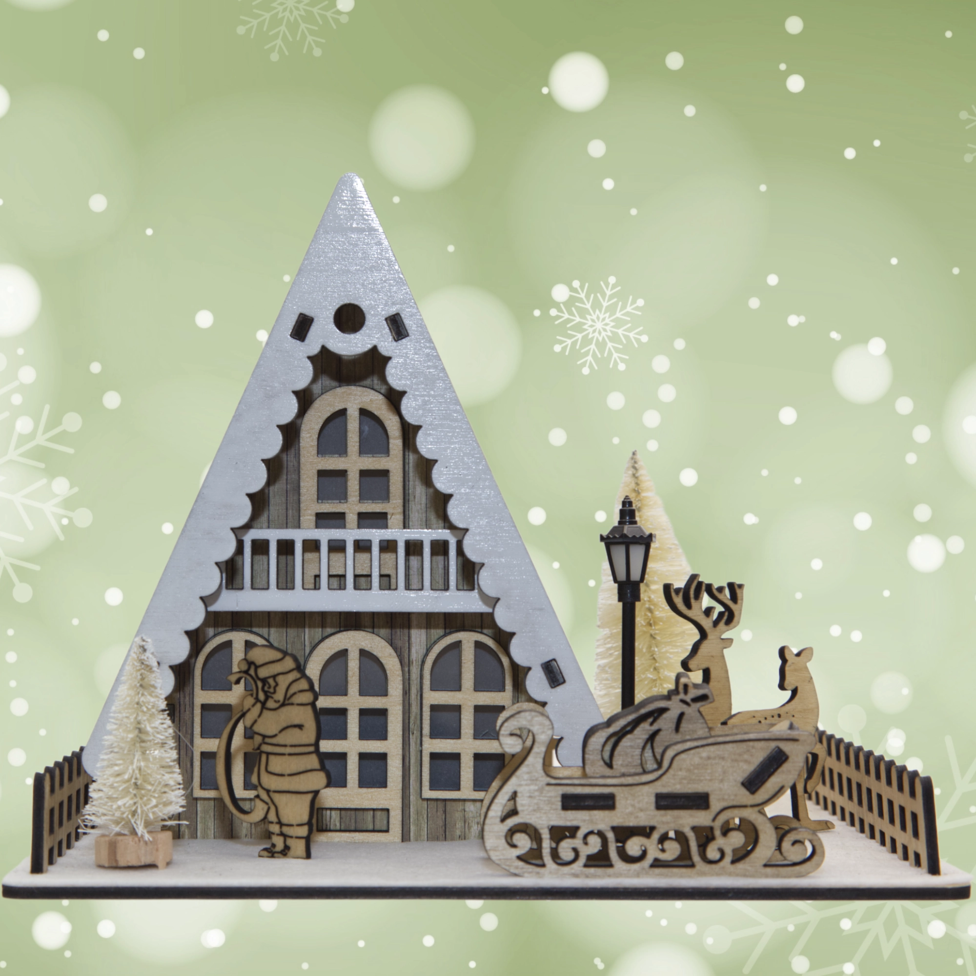 Decorative Christmas scene with a house, reindeer, and sleigh on a green background with snowflakes.