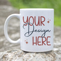 White mug with 'Your Design Here' text on a natural stone surface