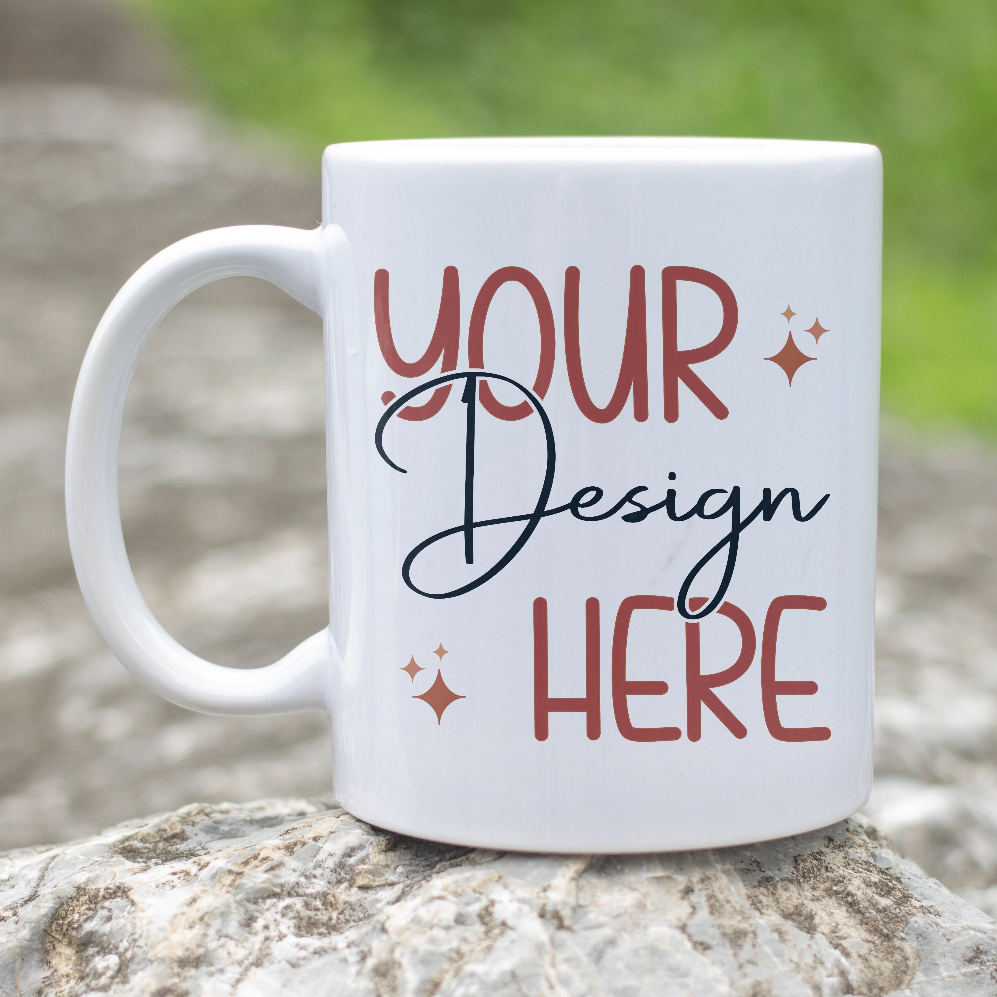 White mug with 'Your Design Here' text on a natural stone surface