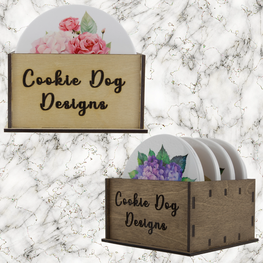 Coasters with floral designs in a wooden holder on a marble background, featuring 'Cookie Dog Designs'.