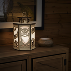 Wooden lantern with owl design on a wooden surface