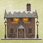 Model of a pub named 'The Vic' with snow on the roof, surrounded by lampposts on a glittery gold background.