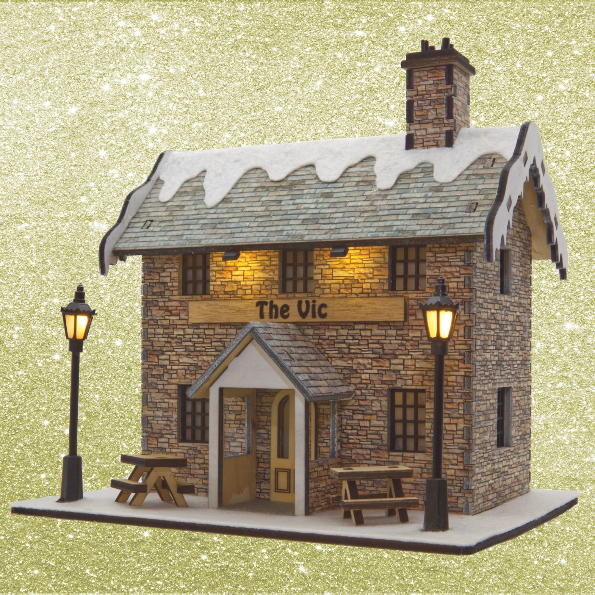 Model of a stone building with 'The Vic' sign on a glittery gold background