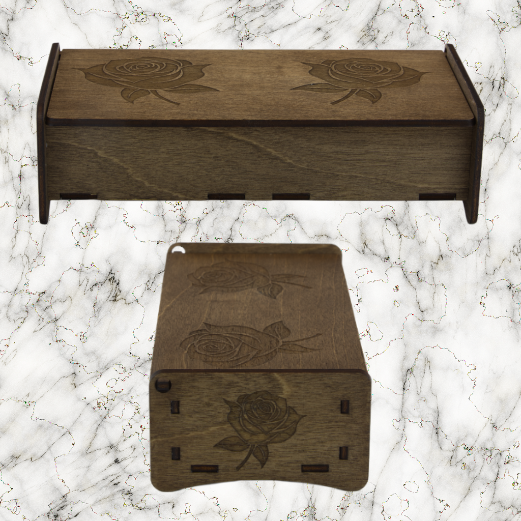 Two wooden boxes with engraved rose designs on a marble surface