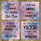 Four motivational coasters with humorous quotes on a wooden background