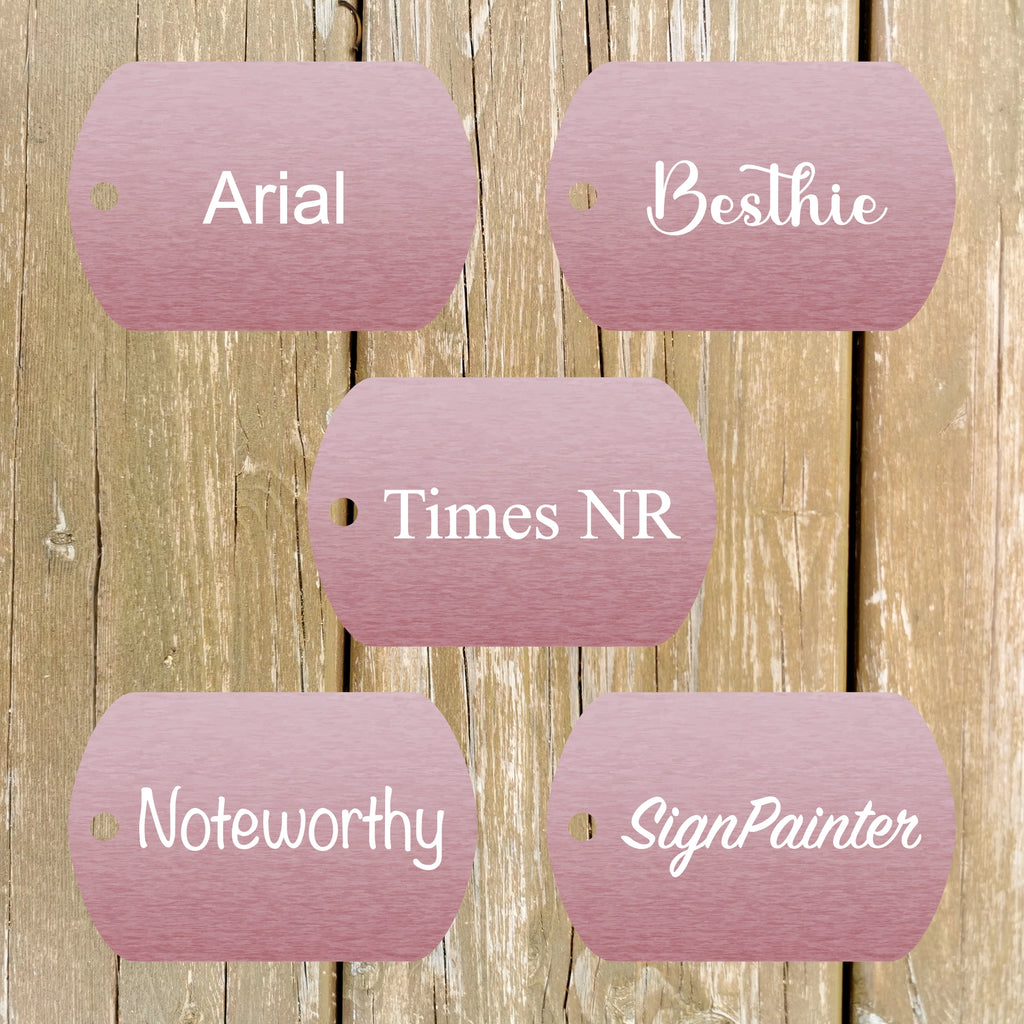 Five pink metallic tags with font samples