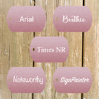 Five pink metallic tags with font samples