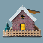 A miniature brick house model with a snow-covered gray roof, a glowing yellow window, and a beige picket fence around it, shown on a plain blue-gray background.